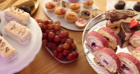 Pastry chef arranging delicious desserts at buffet table, closeup