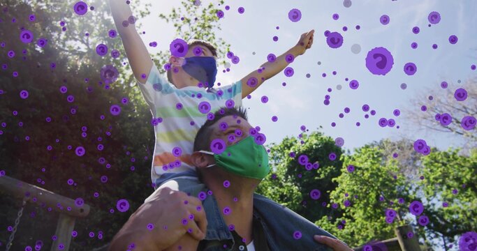 Man carrying boy on shoulders at park, face masks, purple virus overlay, playground beams, chains
