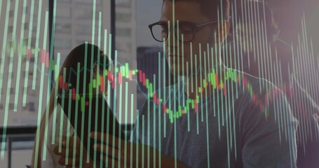 Holding smartphone man wearing sweater analyzing charts by office window over skyline, with laptop