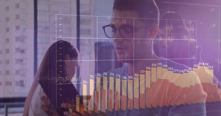 Analyzing charts on tablet, male analyst with glasses collaborating with coworkers in office