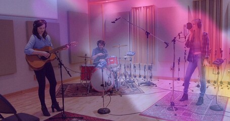 Recording three musicians strumming guitar, playing drums, singing in studio, with microphone gear