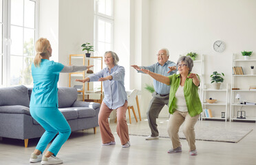 Physician, physiotherapist or health care worker with group of seniors doing exercises for...