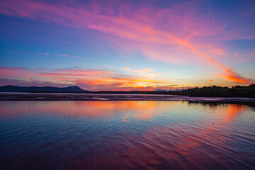 Under a radiant dusk sky, hues of orange and pink melt into tranquil waters. The lake captures every shimmer of the fading light offering a peaceful moment of reflection and harmony with nature.