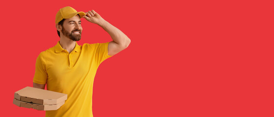 Male courier with pizza boxes on red background