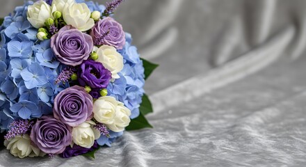 Close up Luxury Bouquet of Purple Roses, Blue Hydrangeas, and White Flowers on an Elegant Gray Velvet Background with Copy Space