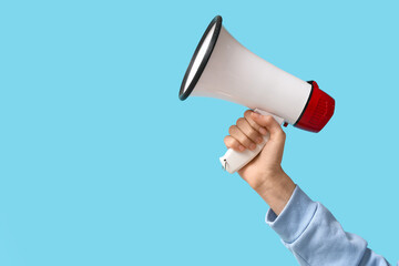 Fototapeta premium Woman holding megaphone on blue background