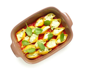 Baking dish of conchiglie pasta stuffed with ricotta, tomato sauce and spinach on white background