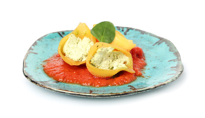 Plate of stuffed conchiglie pasta with cheese, spinach and tomato sauce on white background