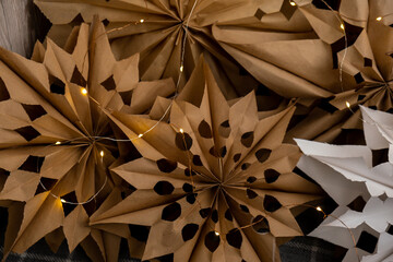 3d craft snowflakes with garland lights. Master class of making craft paper snowflakes for conscientious Christmas decor. Sustainable celebration minimal responsible DIY holiday project. Step by step