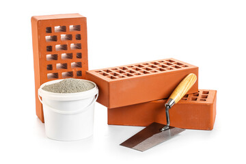 Bricks with spatula and cement on white background