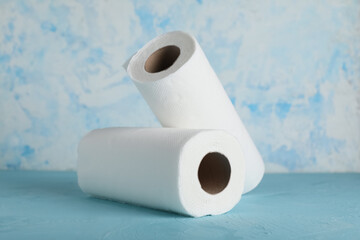 Rolls of paper towels on blue table against grunge wall