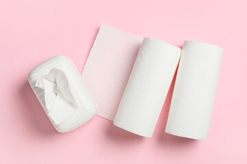 Ceramic holder and rolls of paper towels on pink background