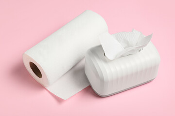 Ceramic holder and roll of paper towels on pink background