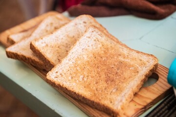 Golden Crunch: Toasted Bread Slices on Wooden Cutting Board with Rustic Charm