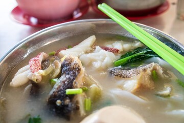 Homestyle Comfort: Clear Fish Soup with Greens and Chopsticks in Traditional Setting