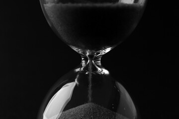 Crystal hourglass on black background, closeup