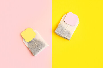 Tea bags with labels on color background