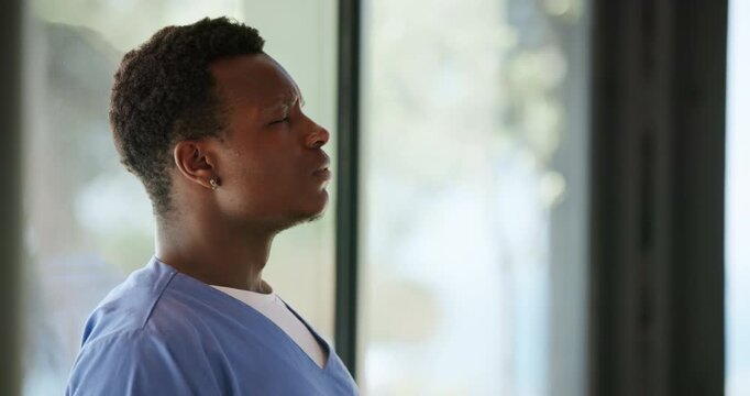 Doctor, sad and black man in hospital thinking of surgery mistake, fail and loss by window. Healthcare, clinic and person with stress, worry and overwhelmed for medical service, crisis and burnout