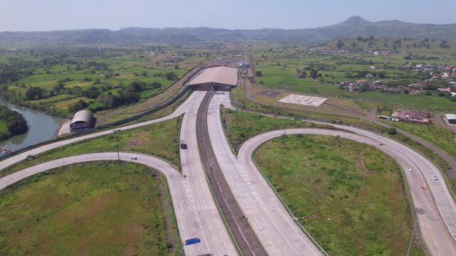 Samruddhi Mahamarg expressway interchange, Kasara Igatpuri tunnel through fertile agricultural fields, rural village and Sahyadri hills, Maharashtra, Drone shot