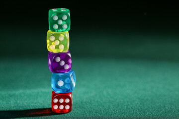 Tower of colorful game dices on green background
