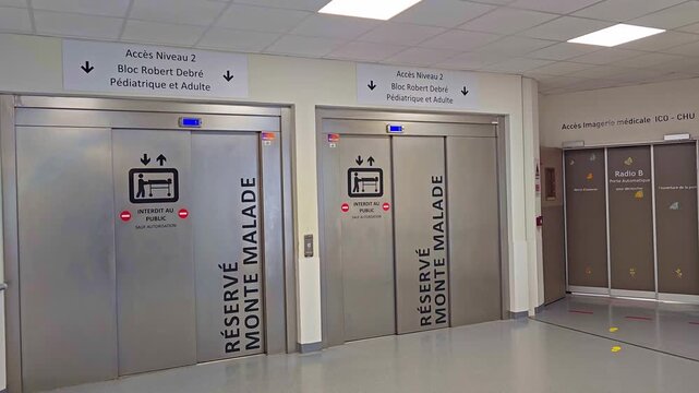 Static view of hospital elevators with medical access signs for pediatric and adult departments