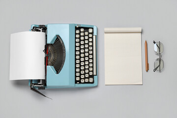 Vintage typewriter with notebook and eyeglasses on white background