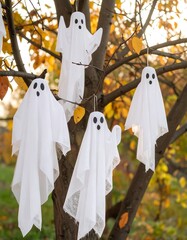 Halloween ghosts hanging from tree branches