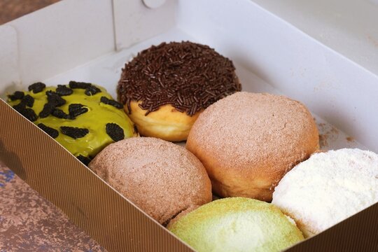 Assorted colorful donuts with milky powder (donat susu) chocolate, and matcha toppings. Popular sweet snack 