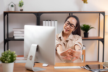 Portrait young asian businesswoman wearing glasses taking a break after overworked with stretching...