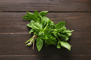 Bunch of fresh green basil leaves on wooden background