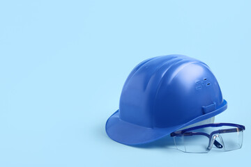 Hardhat with safety goggles on blue background