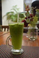 fresh fruit green smoothie in a glass on a table