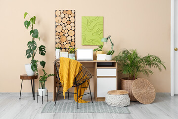 Interior of office with workplace, paintings and houseplants