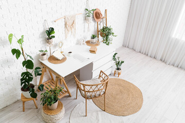 Interior of office with workplace, ladder and houseplants