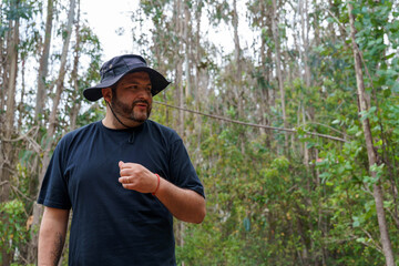 Bearded man exploring forest environment, listening attentively