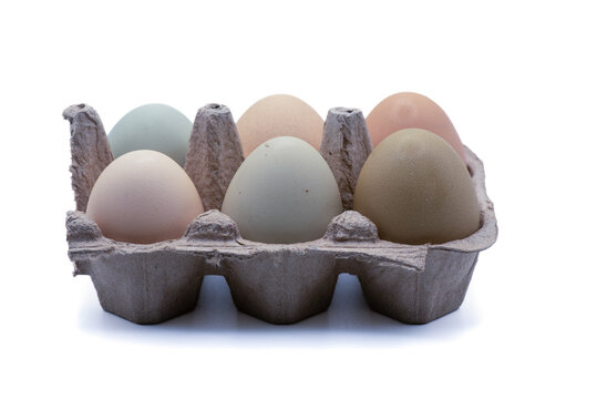 Half dozen unwashed colorful chicken eggs in open cartonon on isolated on white background