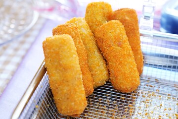 Golden brown fried Indonesian risoles filled with vegetables and served on wire rack.