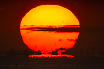 街影蜃気楼の背後に空へ昇るくびれの入っただるま朝日20240901-3