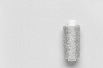 Spool of thread on grey background
