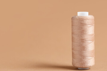 Spool of thread on brown background
