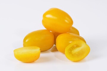 A close-up view of fresh yellow tomatoes arranged on a clean white background.
