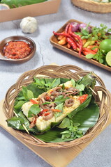 Grilled rice with stir-fried salted squid, wrapped in banana leaves, a traditional Indonesian dish.