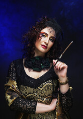 A stylish woman in a vintage hat and chic clothes holds a cigarette holder, preparing to smoke.