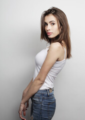 beautiful young woman wearing casual clothes, posing on light grey background.