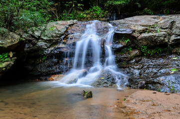 Beautiful Small Waterfall in Green Forest in jungle at Huay U-Mong Nature Trail Chiang Mai, Northern Thailand