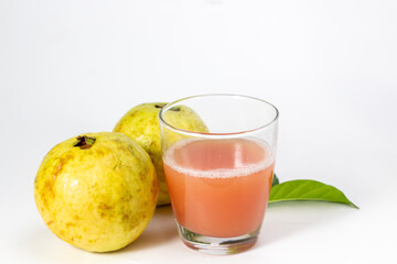 Fresh guava juice is served in a glass alongside whole fruits, offering a healthy and refreshing.