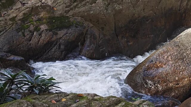 Water stream flowing through rocks with a waterfall in the forset nature