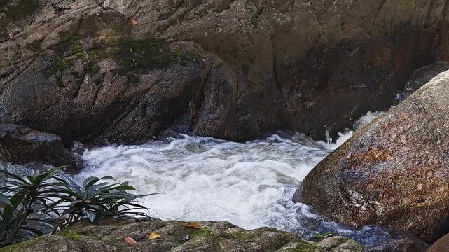Water stream flowing through rocks with a waterfall in the forset nature