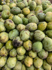 Abundance of fresh green mangos at local farmers market, ready to be enjoyed in healthy recipes and vibrant summer smoothies or tropical fruit salads