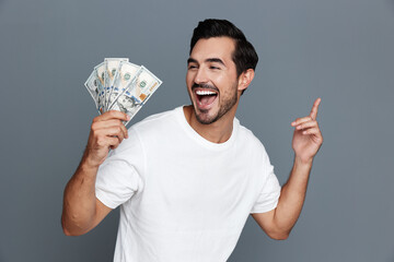 Happy smiling man holding cash in hand with excitement, showcasing his joy and celebration against...